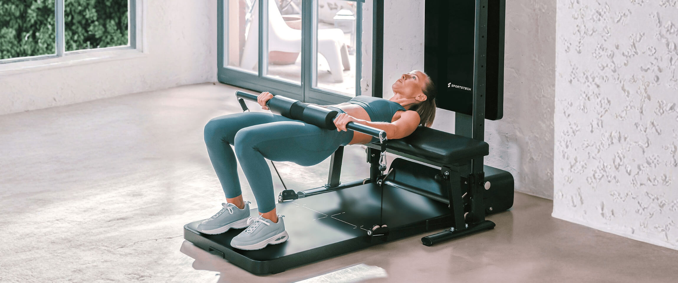 Frau trainiert auf dem sGym Pro zu Hause