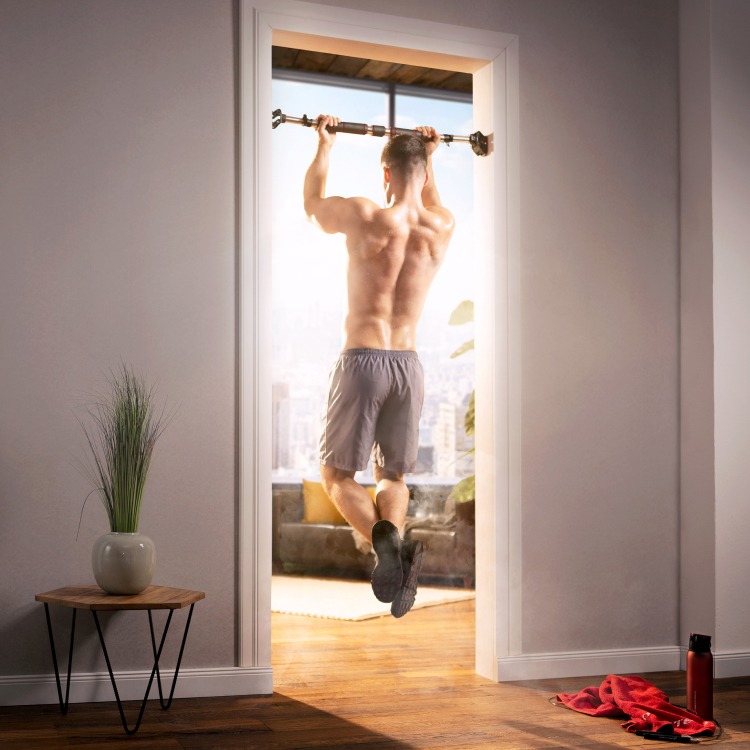 Mann hängend auf Klimmzugstange von hinten